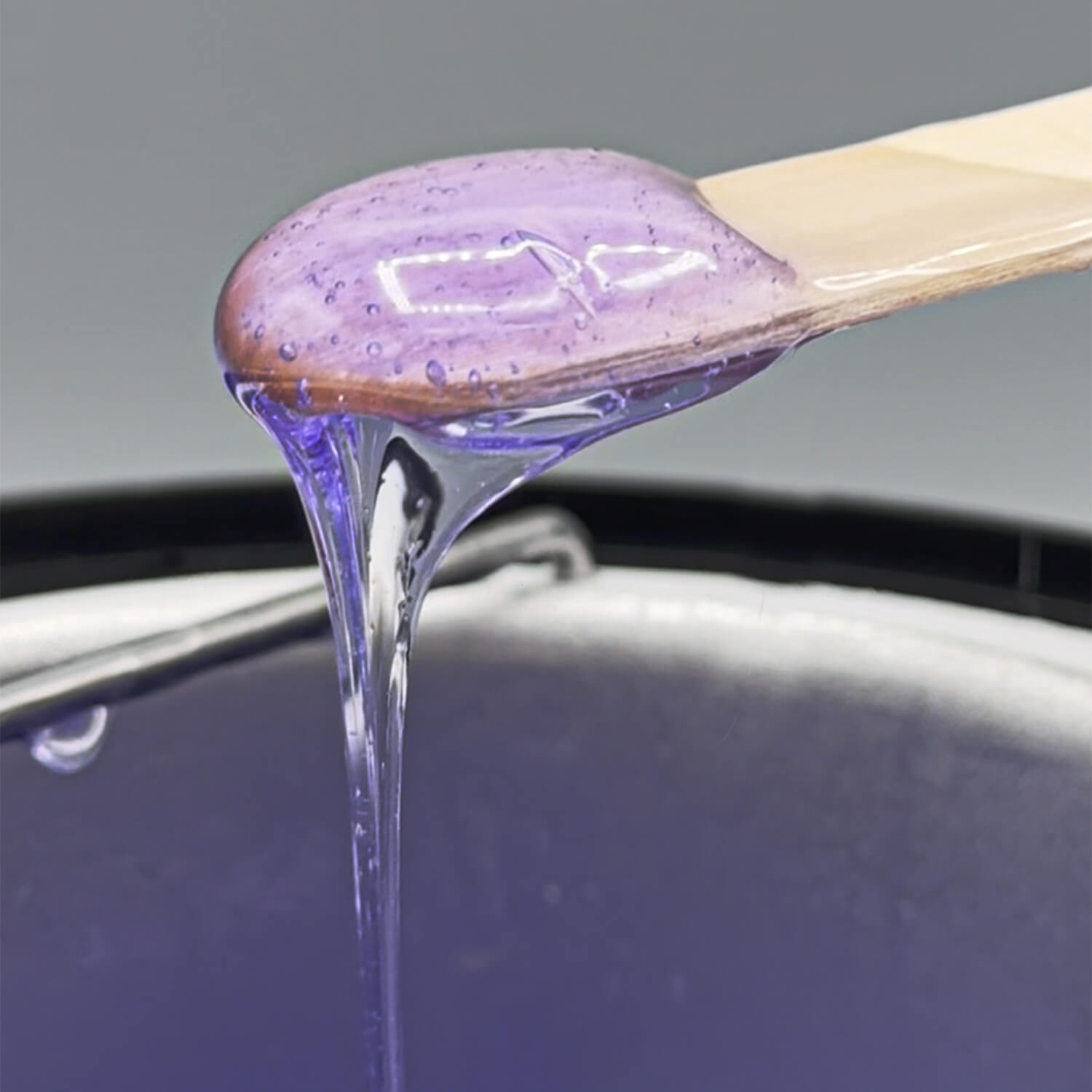 purple hair removal wax on a wooden stick