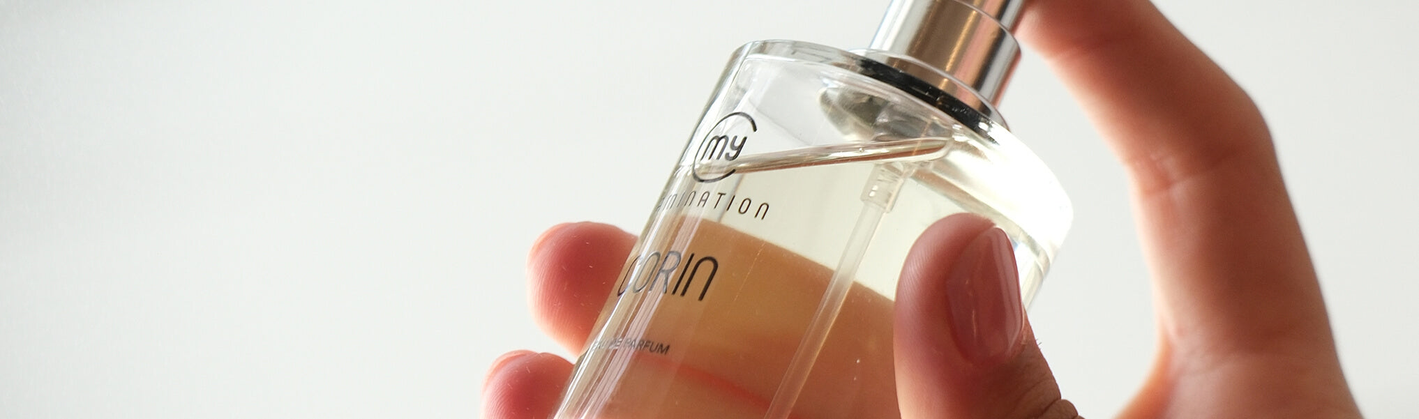 close-up of a hand spraying Corin perfume