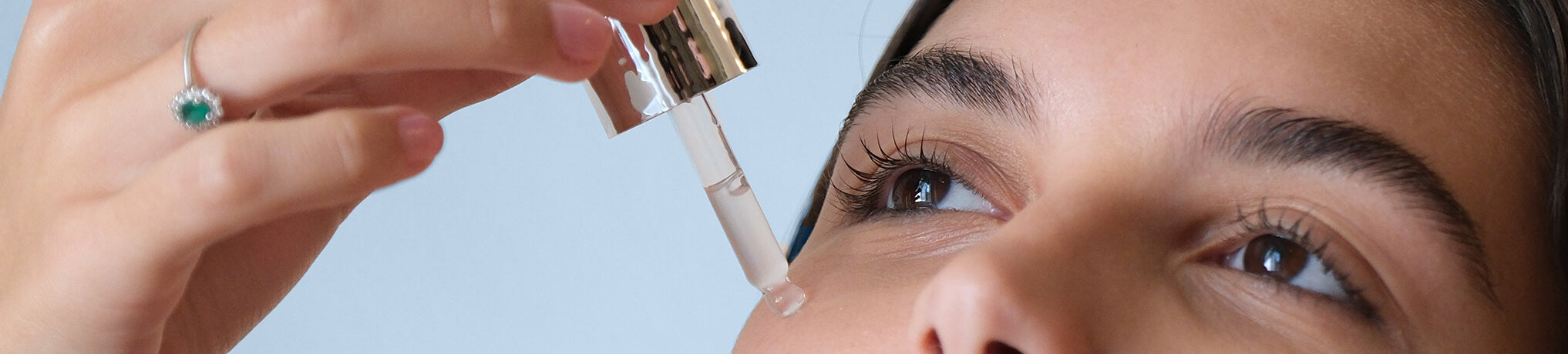 close-up of a girl applying drops of serum to her face my lamination