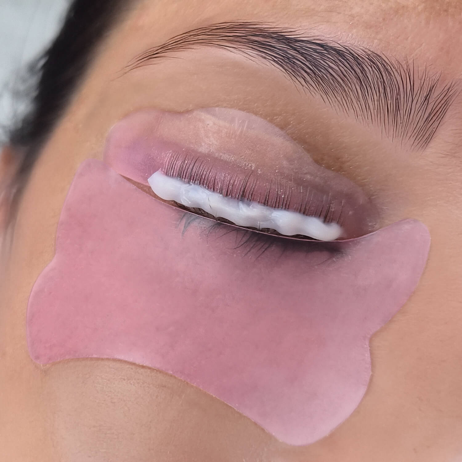 primo piano di un occhio con bigodino in silicone e eye patch durante la laminazione ciglia