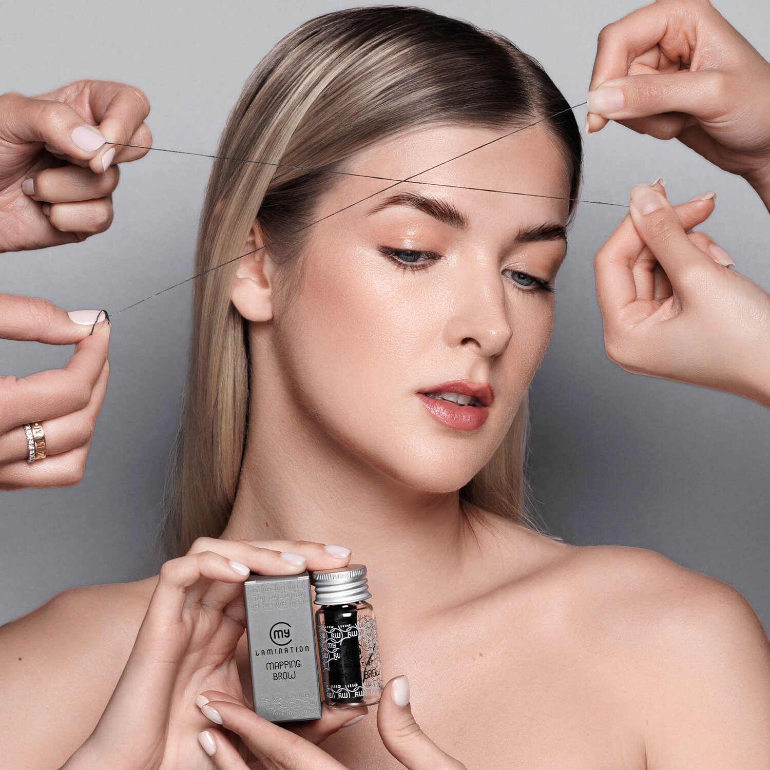 modella bionda regge il mapping brow di my lamination e due fili preinchiostrati vengono appoggiati sul viso 