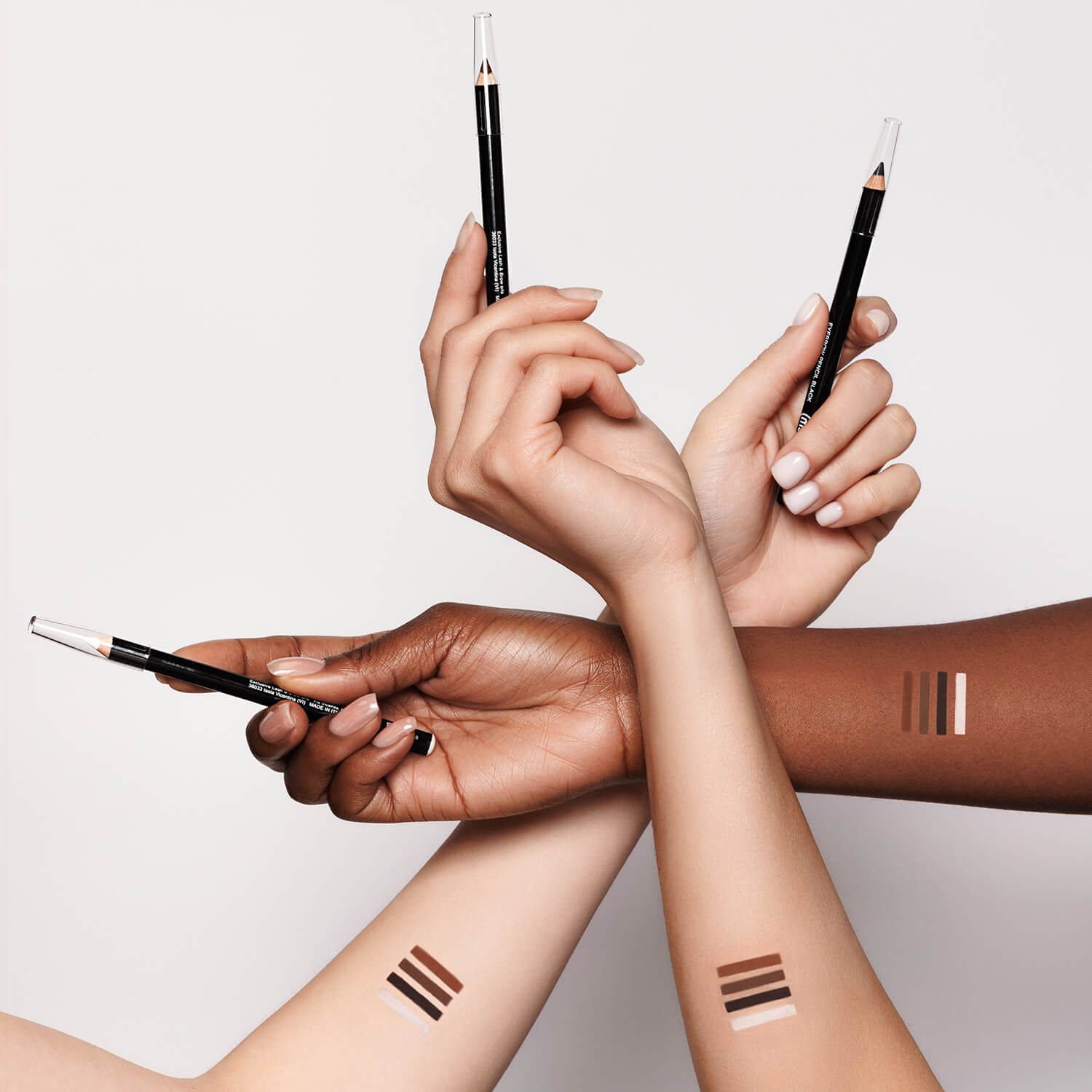 three hands crossing each other, each holding a My Lamination eyebrow pencil between their fingers