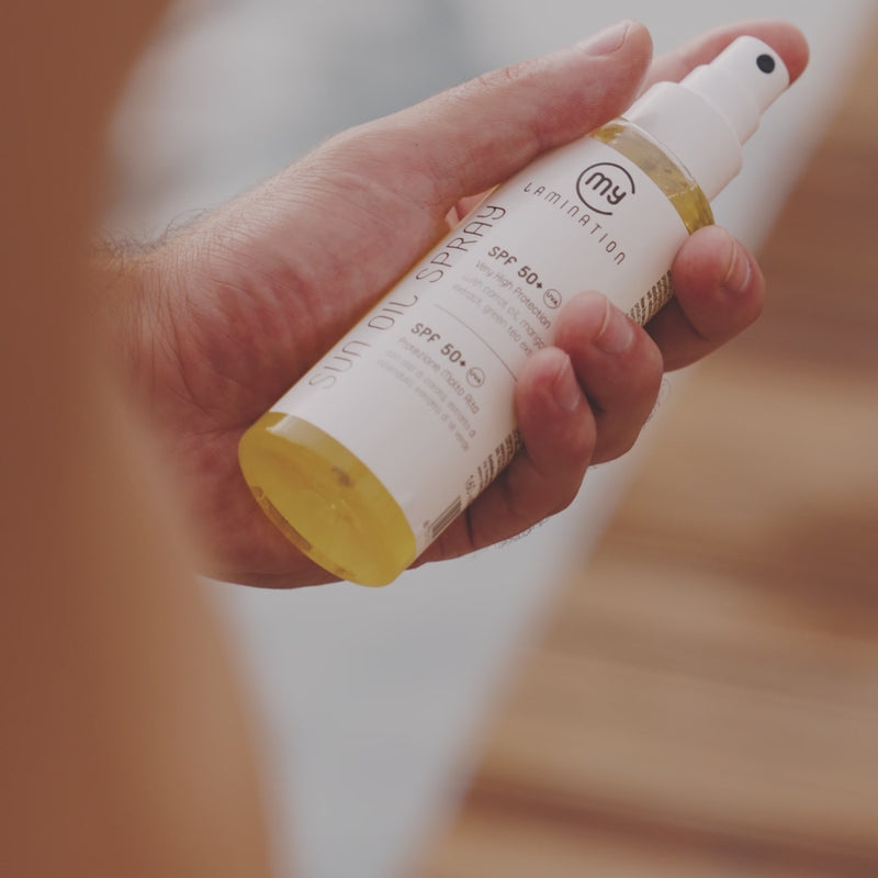 bare-chested man spraying himself with sunscreen my lamination